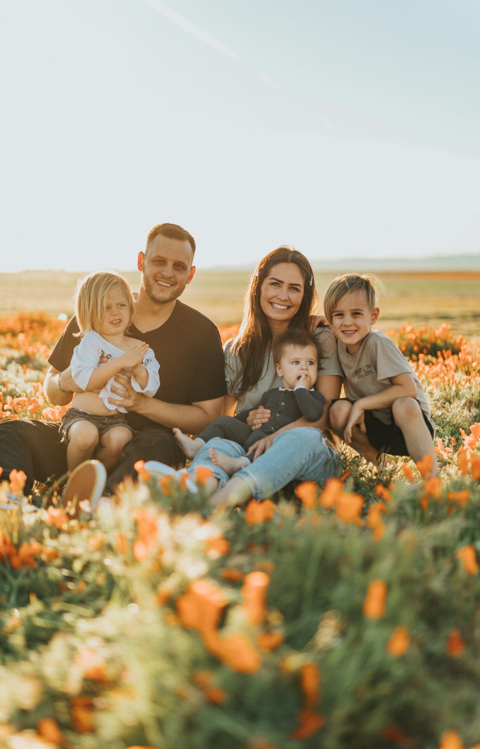 a bilingual family sitting in field